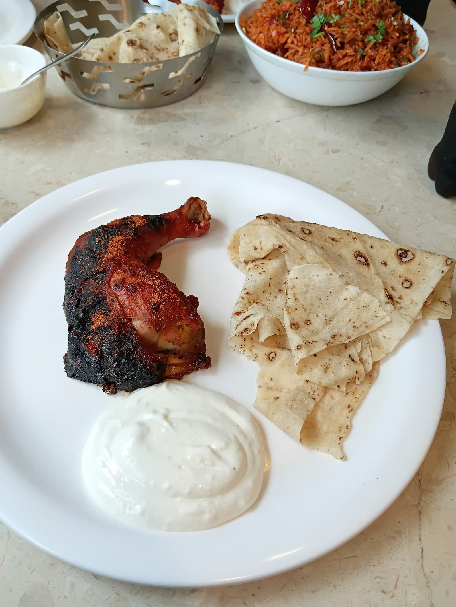 Tandoori chicken served with flatbread and a yogurt dip