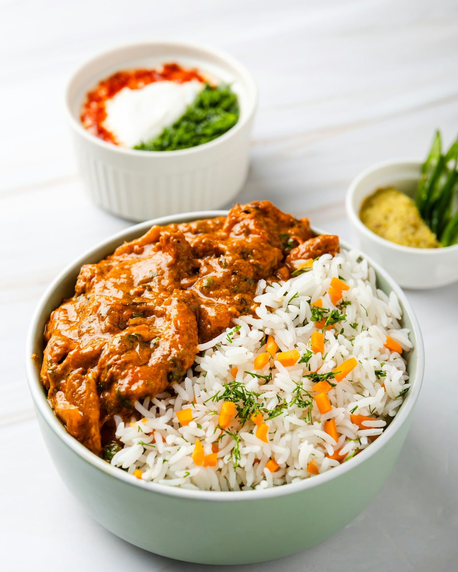 Rich orange coloured makhani curry served in a shallow bowl