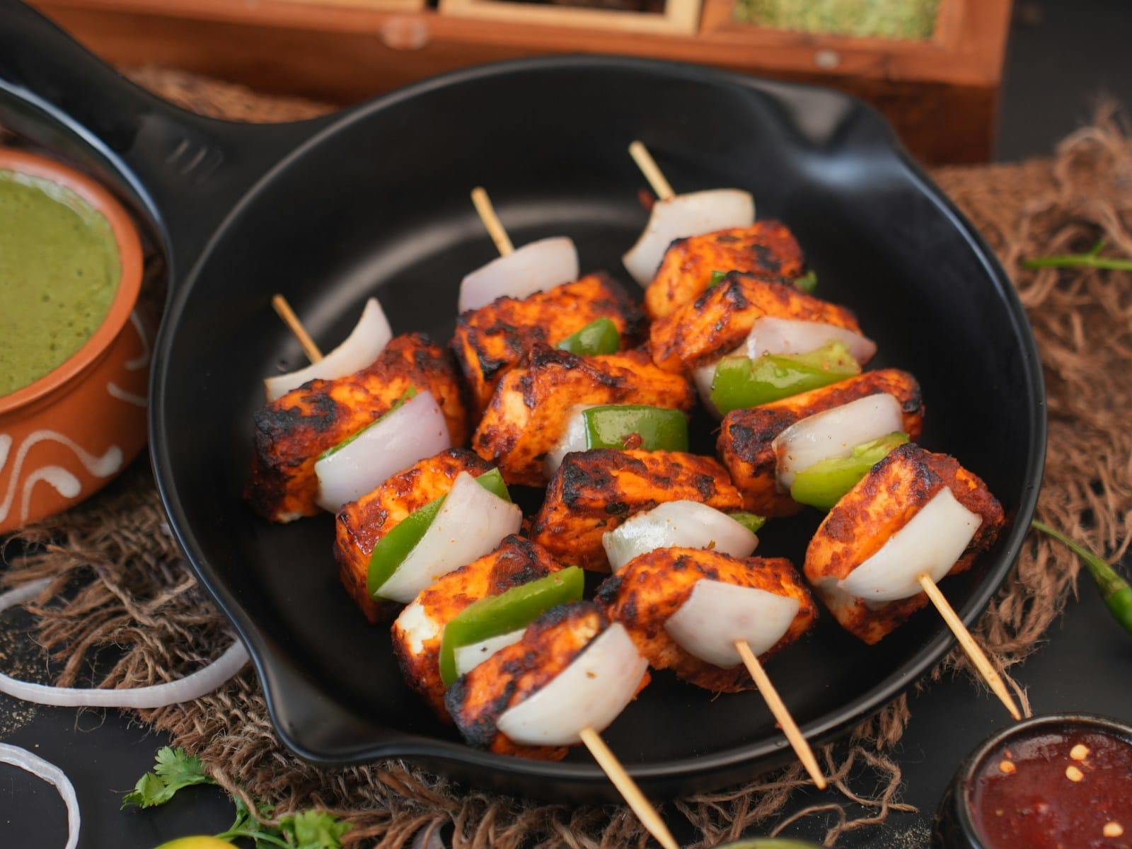 Chicken tikka skewers served in a cast iron pan